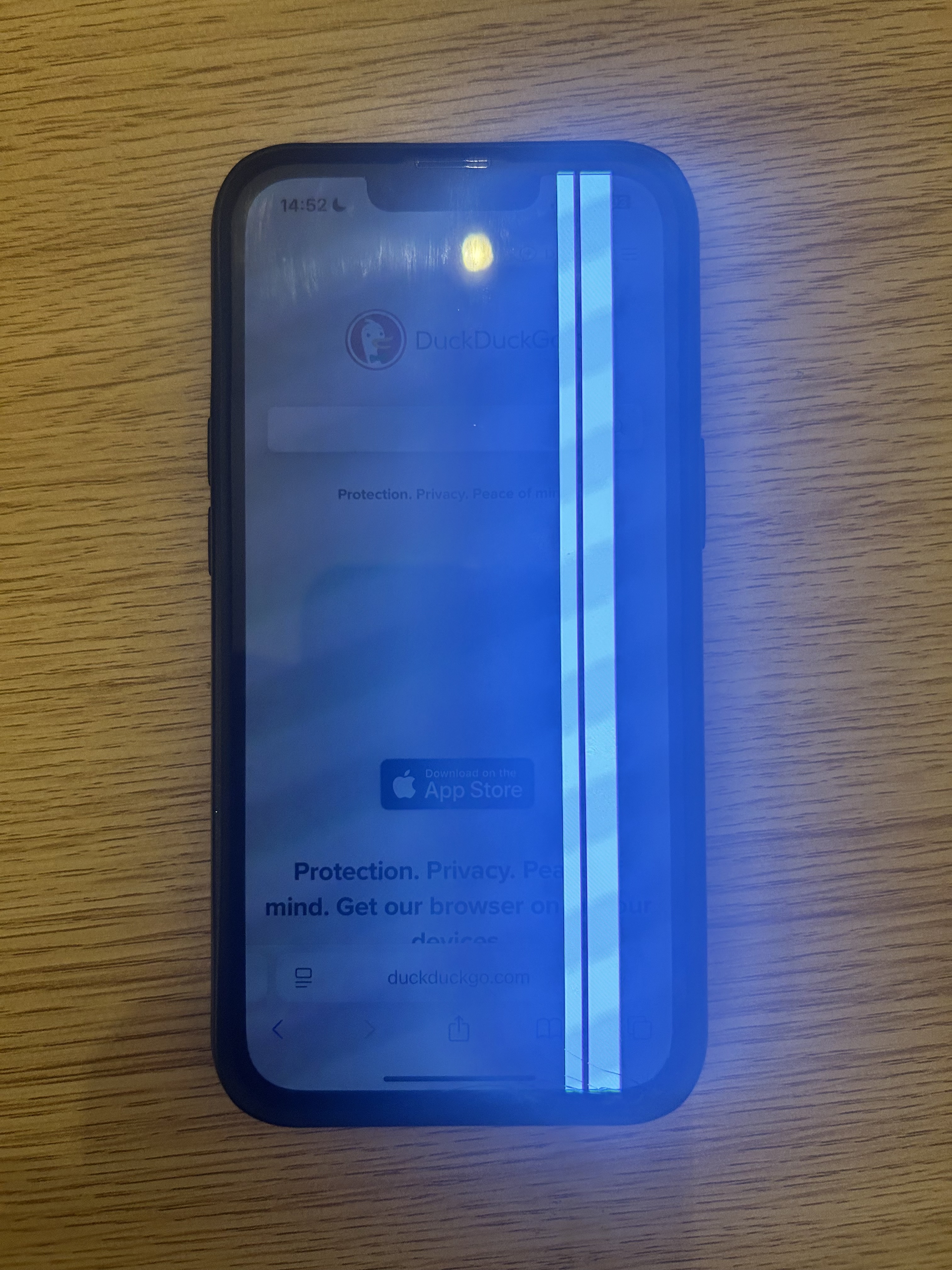 An iPhone 13 with a broken screen. There are two thick white lines in the right half of the screen. The lines are brighter than the rest of the screen.